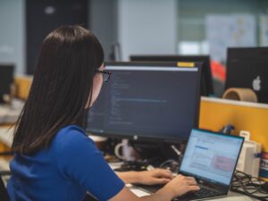 A woman in an office studying examples of customer journey orchestration on her computer