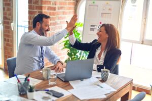 Two marketers high-five after gleaning insights into buyer behavior using a box plot.